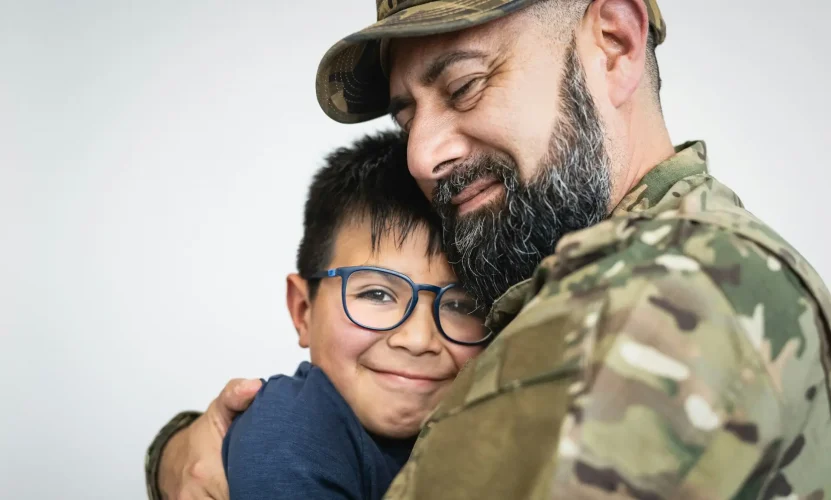 Military soldier embracing his son before leaving for the war